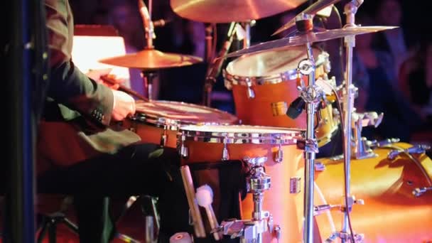 Een man die drums speelt bij het jazzconcert met kleurrijke verlichting - Video