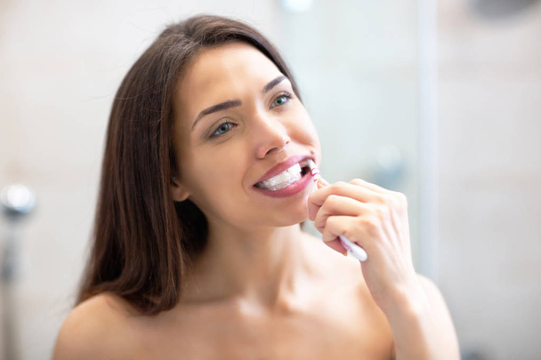 Very pretty girl with brown hair brushing her teeth  - Photo, image