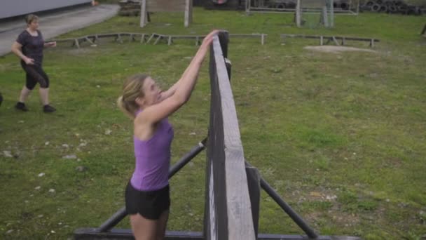 Participantes en muro de escalada de obstáculos - Imágenes, Vídeo