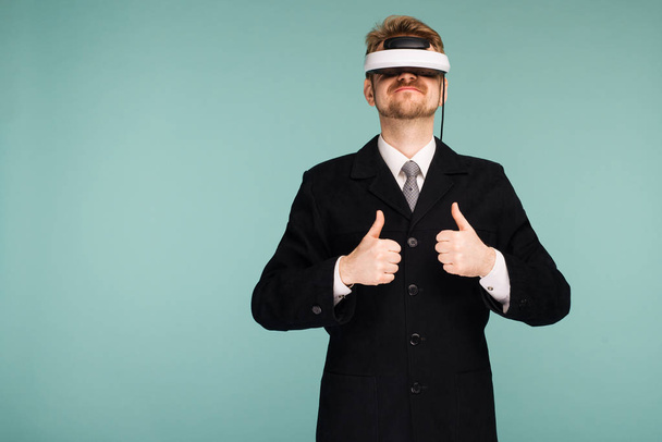 Geschäftsmann in offizieller Kleidung mit Virtual-Reality-Brille, die Daumen nach oben zeigt - Foto, Bild
