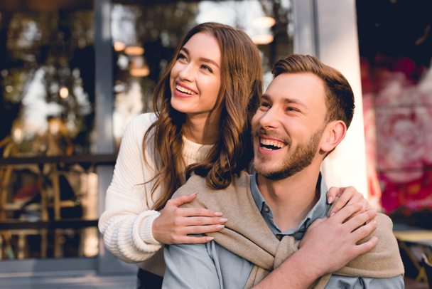 happy girl smiling while hugging handsome bearded boyfriend  - Fotografie, Obrázek