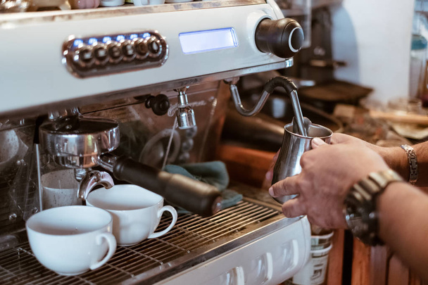 Hand Barista Dampfmilch in Metallbecher auf Kaffeemaschine - Foto, Bild