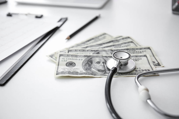 Stetoskooppi rahaa lääkärin pöydälle
 - Valokuva, kuva
