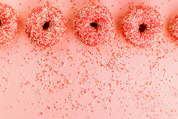 П'ять коралових пончиків. Пончики з глазур'ю на рожевому фоні
. - Фото, зображення