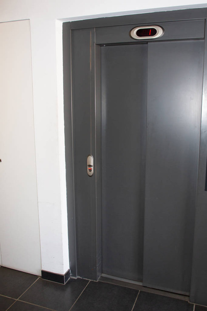 elevador Puertas elevadoras Cerrado gris en pared blanca
 - Foto, imagen