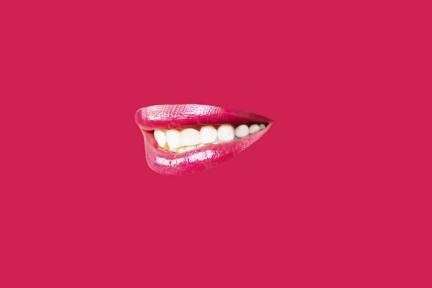 beautiful female smile lips and white teeth close-up on a red background - Foto, afbeelding