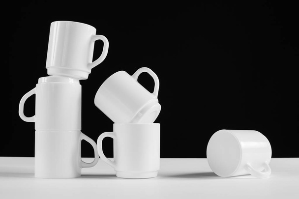 Arrangement of six white mugs with a handle. Black background - Foto, imagen