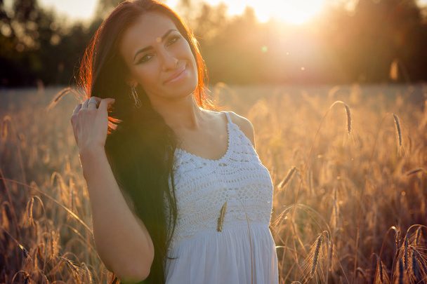 portrait beautiful brunette woman on sunset background in summer - Photo, Image