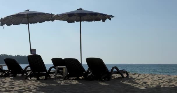 Soleado playa tumbonas sombrillas fondo azul mar
 - Metraje, vídeo