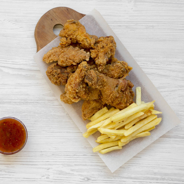 Tasty fastfood: fried chicken drumsticks, spicy wings, French fr - Fotó, kép