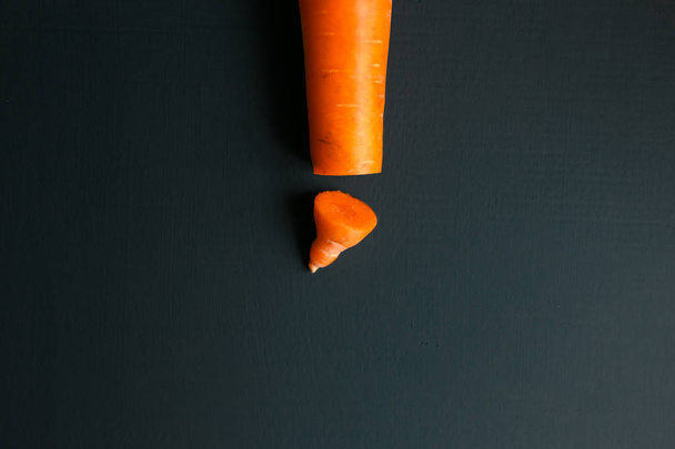 Creative work on male circumcision. Clean pruned carrots and dirty carrots lying on the table. Carrot symbolizes male penis. - Photo, Image