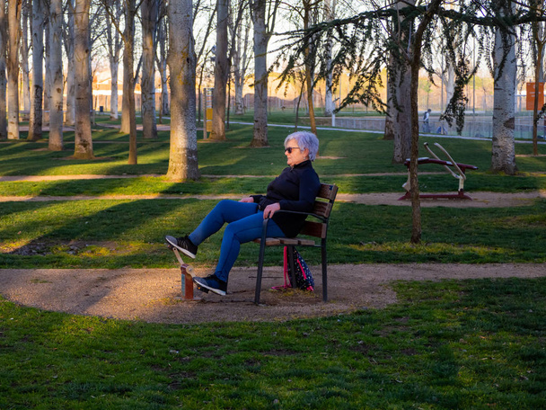 Egy magas rangú nő fehér hajú gyakorló torna egy bio-egészséges parkban - Fotó, kép