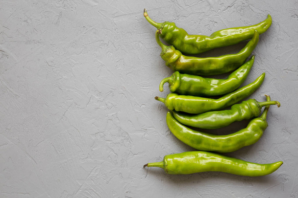 Green chili peppers on gray background. Flat lay, from above, ov - Foto, afbeelding