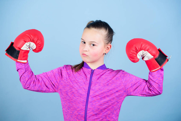 Female boxer. Sport upbringing. Boxing provide strict discipline. Girl cute boxer on blue background. With great power comes great responsibility. Contrary to stereotype. Boxer child in boxing gloves - Fotoğraf, Görsel