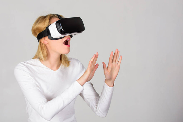 Женщина в очках виртуальной реальности. Человек с шлемом виртуальной реальности изолирован на сером фоне. Женщина с гарнитурой виртуальной реальности. VR-игры
. - Фото, изображение