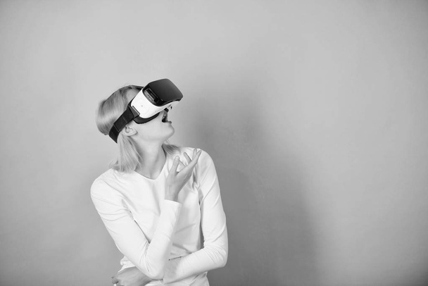 Woman with virtual reality headset. Young woman using a virtual reality headset. Funny young woman with VR. Games outline. - Fotografie, Obrázek