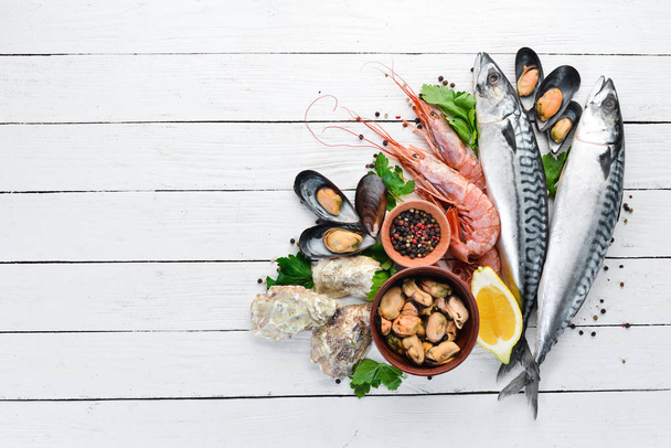Seafood on a white wooden background. Fresh fish, shrimp, oysters and caviar. Top view. Free copy space. - Фото, зображення
