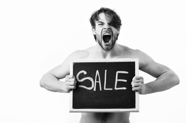 Bearded man, short beard. Caucasian sexy young shouting macho with stylish hair, moustache with muscular torso holding black board with sale inscription isolated on white studio backgroun - Foto, afbeelding