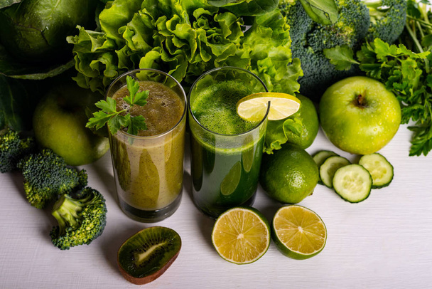 Batido verde kiwi y bebidas de coliflor sobre fondo de madera blanca. Comida y bebida cruda
. - Foto, Imagen