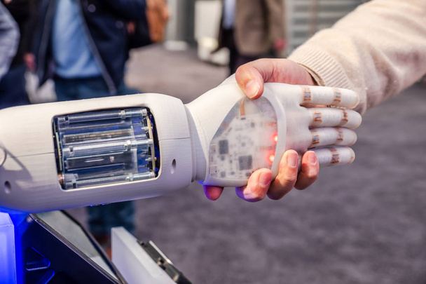 Human hand and robots as a symbol of connection between people and artificial intelligence technology - Photo, image