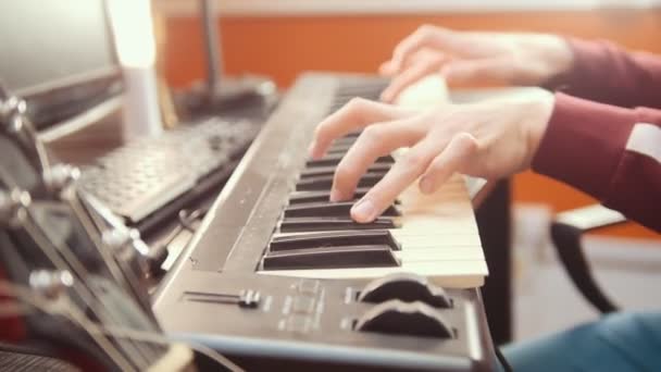 Muzyk grający na klawiaturze MIDI w studiu dźwiękowymi - Materiał filmowy, wideo