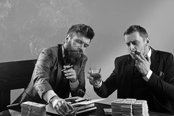 The work is done. Business partners with cash money. Successful investment in business. Businessmen write financial report while drinking and smoking. Money brokers counting profit increase - Foto, Imagen