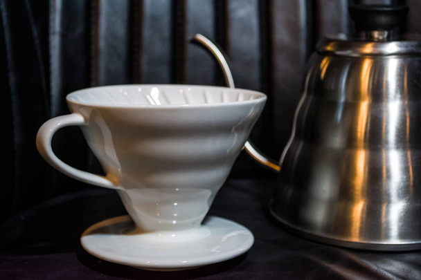 Entonnoir blanc Pourover sur fond noir pour la préparation du café par une méthode alternative. Travailler le barista dans un café
.  - Photo, image