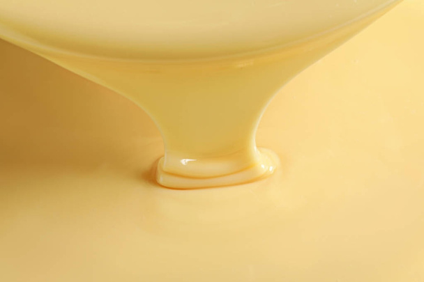 Tasty pouring condensed milk as background, closeup. Dairy product - Photo, image