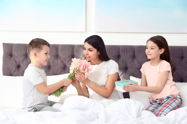 Son and daughter congratulating mom in bed. Happy Mother's Day - 写真・画像