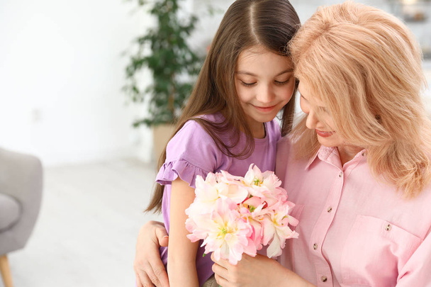 Little daughter congratulating her mature mom at home, space for text. Happy Mother's Day - Фото, зображення