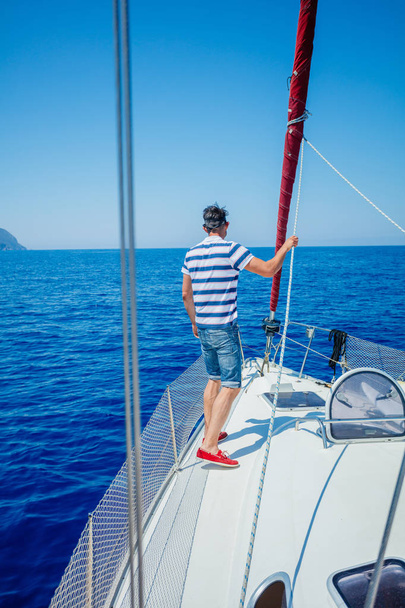 Young man sailing yacht. Holidays, people, travel - Foto, imagen