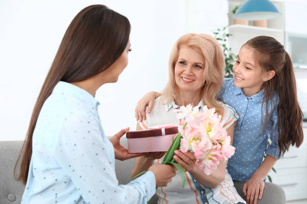 Woman and her daughter congratulating granny at home. Happy Mother's Day - Фото, зображення