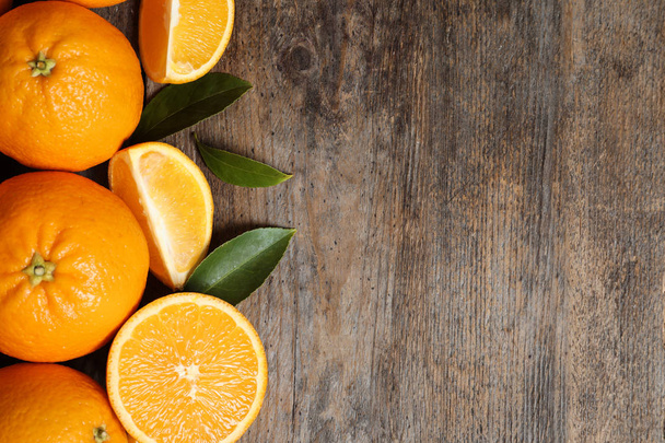 Flat lay composition with ripe oranges and space for text on wooden background - 写真・画像