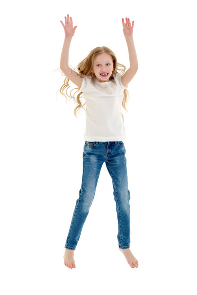 A little girl in a pure white t-shirt is jumping. The concept of - Foto, imagen