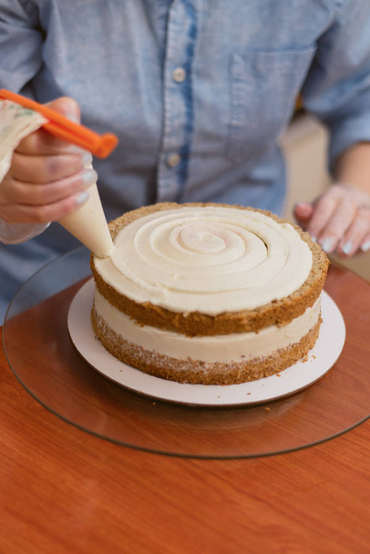 confiseur presse la crème sur le gâteau. Fille faire un gâteau
 - Photo, image