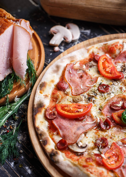 Pizza with sausages, ham, mushrooms and tomatoes - Zdjęcie, obraz