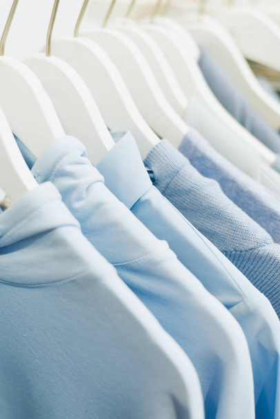 Blaue Damensachen hängen an Kleiderbügeln im Laden. - Foto, Bild