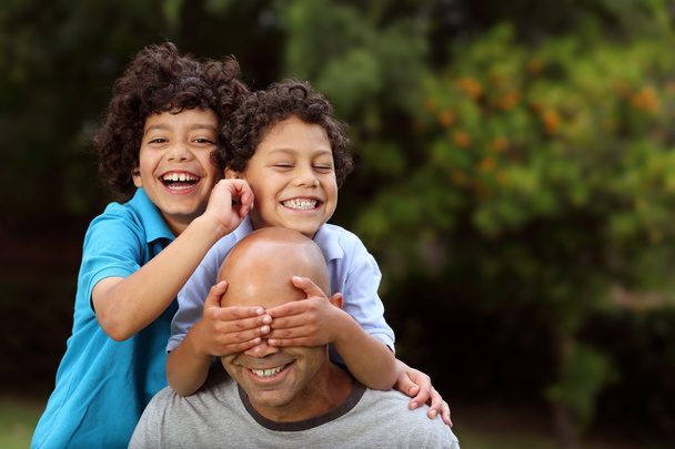 Mixed race father and sons playing outside - Photo, Image
