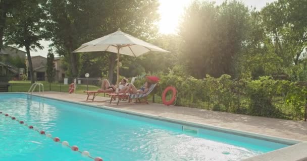 Mooie romantische paar ontspannen en zonnebaden in de buurt van zwembad in luxe landelijke villa huis. De Italiaanse reis vrienden in slowmotion Umbria.4k - Video