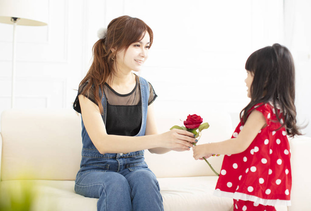 little girl  giving a flower to her mother - Foto, immagini