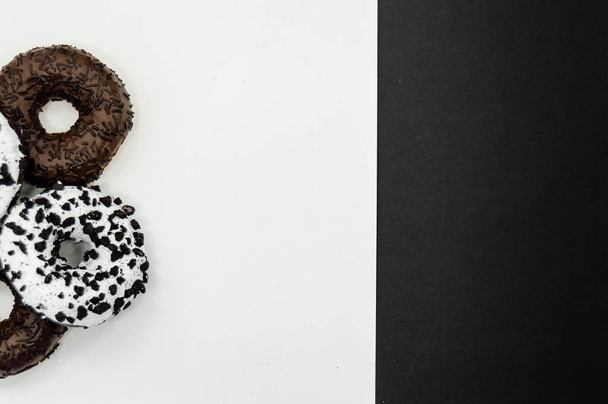 Пончики с шоколадным глазурью с пончиками посыпать изолированы на белом черном абстрактном фоне
 - Фото, изображение