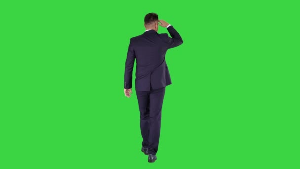 Επιχειρηματίας περπατώντας και κοιτάζοντας μακριά σε μια πράσινη οθόνη, πλήκτρο αποχρώσεων. - Πλάνα, βίντεο