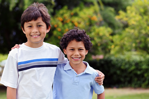 dwa uśmiechający się szczęśliwy mieszanej rasy młodych chłopców - Zdjęcie, obraz