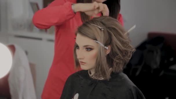 Professional hairdresser does a girls hairstyle for a photo shoot. - Felvétel, videó