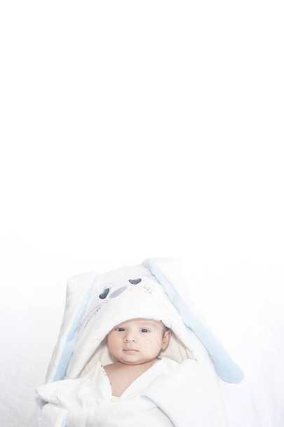 Симпатичный новорожденный мальчик на белом фоне. Прекрасный ребенок был одет в костюм кролика с длинными ушами. Праздник Пасхи
. - Фото, изображение