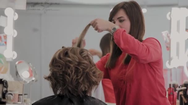 プロの美容師は、写真撮影のための女の子の髪型をします. - 映像、動画
