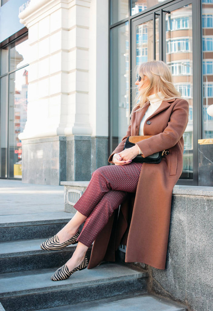 Stylish fashionable blonde woman wearing coat and sunglasses, street style photo - Foto, Imagem