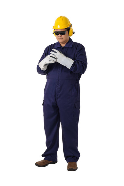 Portret van een werknemer in de mechanische jumpsuit is het verwijderen van handschoenen ISO - Foto, afbeelding