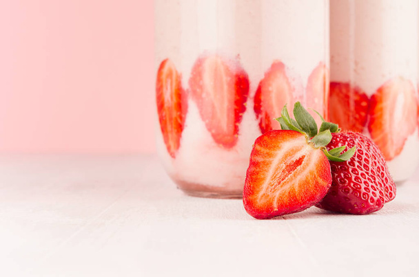 Strawberry milkshake in jar  with slices ripe berry closeup, detail on gentle pastel pink and white background, copy space. - Foto, Imagem