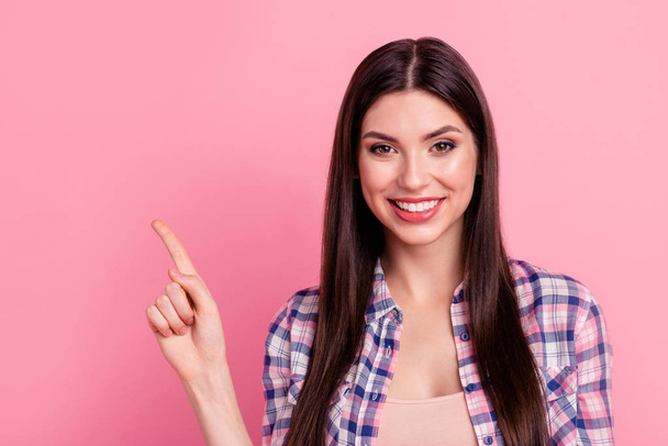 Close up photo funky beautiful her she lady hand arm index finger indicate empty space promotional advising buy buyer offer wear casual checkered plaid shirt clothes outfit isolated pink background - Photo, image